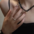 Primer plano de collar de cuentas negras con colgante de gota dorada en una modelo - Dorado