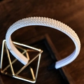 Elegant white pearl headband for brides on a gold display stand with dark wood background - Style 5