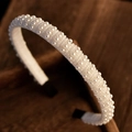 Elegant bridal headband with multiple rows of white pearls on a soft fabric base - Style 3
