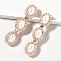 Close-up of golden hair clips featuring white oval pearls and sparkling rhinestones - Triple Pearl Rhinestone (Style 1)