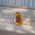 Dettaglio di un anello dorato vintage con fiori secchi conservati in resina ambrata - Base Oro Irregolare Floreale Arancio Viola / Serie Marrone