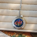 Detailed close-up of a silver locket with red dried flowers and a pearl accent - Dark Blue Base Red Flower Round Style (D)