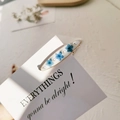 Dettaglio fermaglio per capelli con fiori secchi blu, perle bianche e bordo dorato - Base Bianca Nontiscordardimé