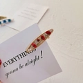 Dettaglio di un fermaglio dorato con fiori essiccati rossi e perle in resina trasparente - Base Conchiglia Gipsofila