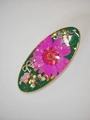 Detail einer grünen Harz-Haarspange mit rosa Trockenblume und goldenen Schleifenakzenten - Ovaler Entenschnabel-Clip