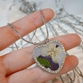Close-up of heart-shaped pendant with dried pansy flower and sparkling crystal frame - Purple Pansy Style (Style A)