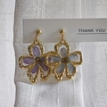 Detailopname van gouden oorbellen met echte gedroogde bloemen in paars-blauw hars - Paars/Blauw Geperste Bloemen Stijl (A)