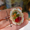 Macro dettaglio di una spilla vintage in resina con fiori e misura 4 cm x 3 cm - Stile Petalo di Rosa