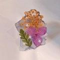 Detailed close-up of handmade resin ring with purple flowers and small white pearls - Hydrangea