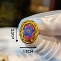 Detail view of oval resin ring with blue dried flowers and golden braided frame - Blue Dried Flower Woven Pattern (Style B)