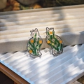 Macro detail of handmade cat earrings featuring real dried flowers in clear resin - Green Series Earrings / Green Series Earrings