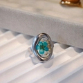 Detail of handmade stainless steel ring with blue dried flower in clear resin - Blue