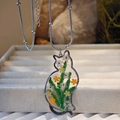Detailed close-up of a cat-shaped resin necklace featuring yellow and white dried flowers - Green Series Necklace / Green Series Necklace
