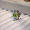 Macro shot of silver stainless steel ring with green dried flower in clear resin - Green