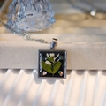 Detailed macro of square resin pendant with dried flowers and shimmering shell stones - Square Style A