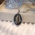 Macro detail of oval dried flower pendant with purple botanicals and silver chain - Oval Style A