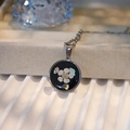 Macro shot of handmade necklace with dried white flowers and shell bits in resin - Round Type A