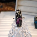 Vue macro de la bague en résine avec fleurs séchées blanches et violettes sur cristal - Perle d'Émeraude