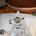 Macro detail of handmade resin ring with white dried flower and abalone shell flakes - Pearl Plum