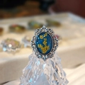 Detailed macro view of vintage resin ring featuring dried yellow flowers and silver lace frame - E Style Antique Silver