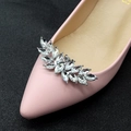 Detailed close-up of leaf-shaped marquise rhinestone shoe clip on pink leather pumps - Silver