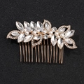 Detalle de peineta para novia con hojas doradas, perlas blancas y pedrería brillante - KC Dorado