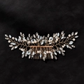 Dettaglio del pettine da sposa oro rosa con cristalli e perle su sfondo in pelle - Oro (TS843)