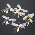 Dettaglio di 5 accessori sposa con fiocchi di pizzo bianco e perle rosa su sfondo nero ruvido - Set di Gioielli Rosa