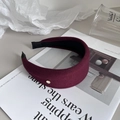 Detailed side view of a wide burgundy fabric headband with a small gold metal emblem detail - 4CM Inner Band Width / Burgundy