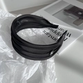Detail of the triple-layered black satin headband with a small white bow logo accent - Black