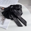 Elegante pinza per capelli in raso nero a doppio fiocco con farfalla di cristallo su tavolo - Nero