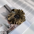 Close-up of olive green fabric scrunchie with woven label on aesthetic magazine background - Dark Yellow