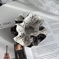 Dettagli dello scrunchie in pizzo scozzese che mostra le trame su una rivista - Scrunchie / Marrone