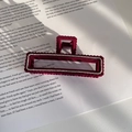 Elegant wine red velvet hair claw with rhinestones on a magazine under soft light shadow - Red