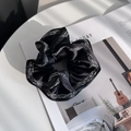 Elegante elastico scrunchie in raso nero con bordo di perle su una rivista trendy - Nero