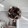 Detail van een bloemen scrunchie met geplooide randen en een handgemaakt labeltje - Bloemig Contrast Stijl / Bruin