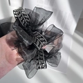 Detalle de coletero de malla negra con elegante adorno metálico de hojas y strass - Negro