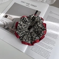 Dettaglio di un elastico floreale con motivo a fiori grigi e strato interno in tessuto rosso - Rosso
