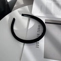 Dettaglio di un cerchietto in velluto nero fatto a mano con etichetta laterale chic - Nero