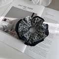Vista dettagliata dell'elastico per capelli a fiori blu con pizzo su sfondo di rivista - Blu