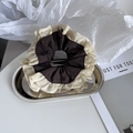 Detail van een tweekleurige geplooide scrunchie in beige en bruin op zilveren dienblad - Beige