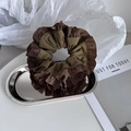 Detail van tweekleurige scrunchie in bruin en legergroen op een zilveren dienblad - Bruin