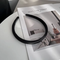 Detalle de una diadema de satén negro con etiqueta hecha a mano en una revista - Negro