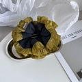 Detail van een olijfgroene en zwarte scrunchie op zilveren dienblad met stoffen label - Marineblauw