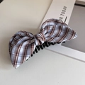 Eleganter lilabrauner Haarclip mit Karomuster und Schleife sowie silbernem Etikett - Himmelblau