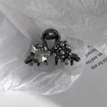 Détail de la pince à cheveux en métal noir avec strass en cœur et perles grises - Style Nœud