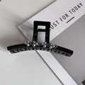 Dettaglio della grande pinza per capelli nera con perle grigie e strass viola lucidi - Grigio