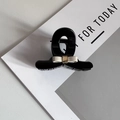 Detailed close-up of a black resin hair claw clip with an elegant beige silk bow decoration - Black