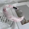 Gros plan du serre-tête en satin rose avec broderies florales mauves et rembourrage - Rose foncé