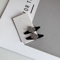 Détail de deux mini barrettes noires avec fleur en strass sur une carte de support - Style Trèfle à Fleurs / Base Noire Strass Argenté